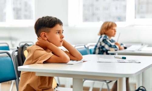 Back to school. Children sitting at their desks in the classroom and listening to the teacher. Schoolchildren studying at school in a modern classroom. The concept of science and education.