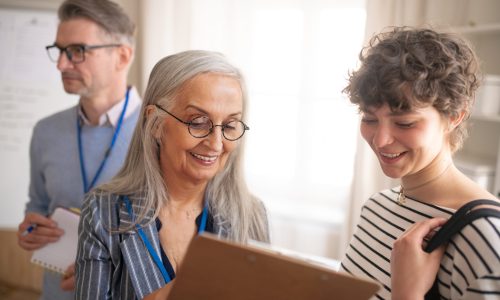 A job centre employee helping young woman to fill form to find a job.