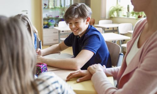 Schoolchildren studying together in classroom
