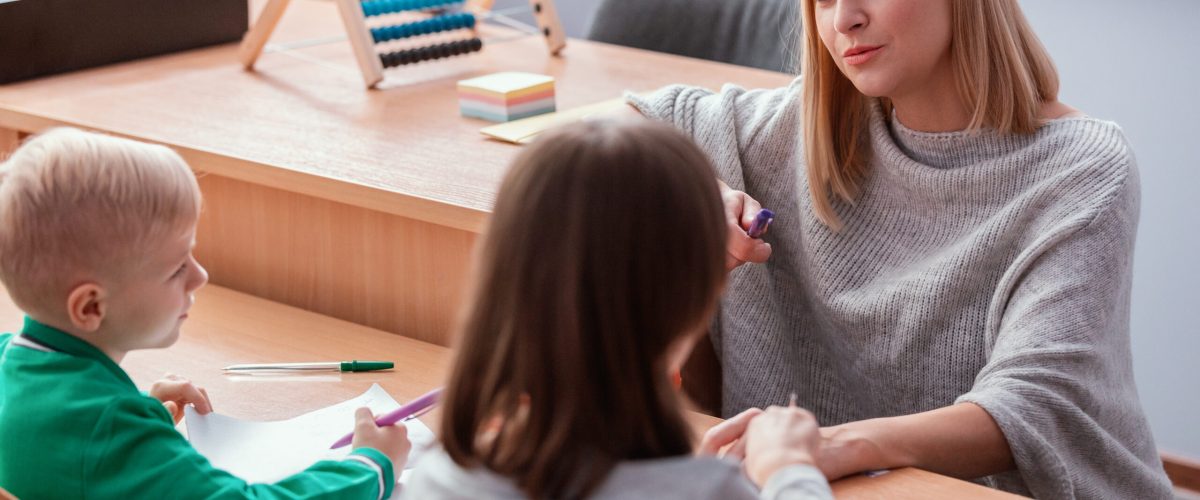 Młody nauczyciel i uczeń w klasie podczas lekcji