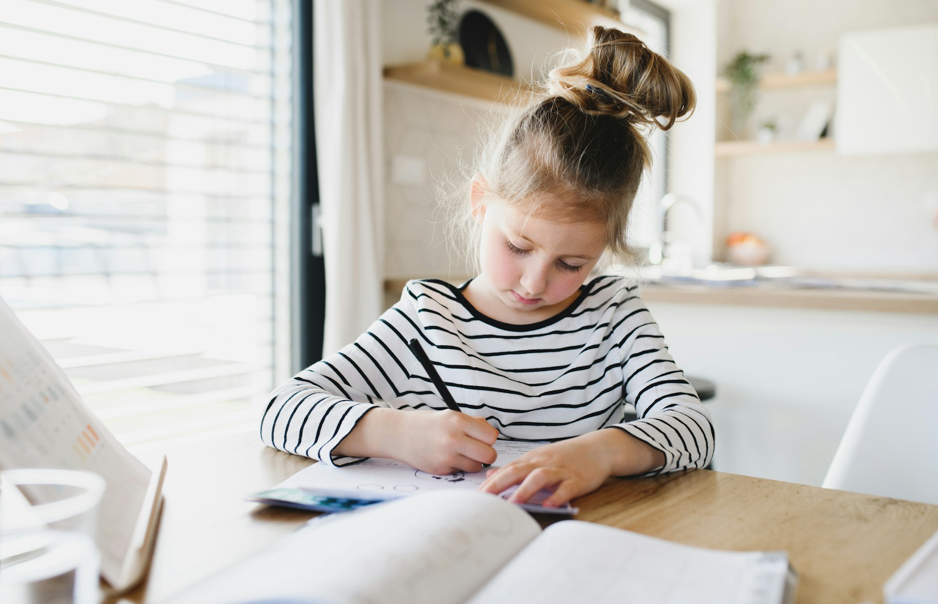 Diagnoza dysleksji, dysgrafii, dysortografii. Dziewczynka rozwiązuje zadania domowe