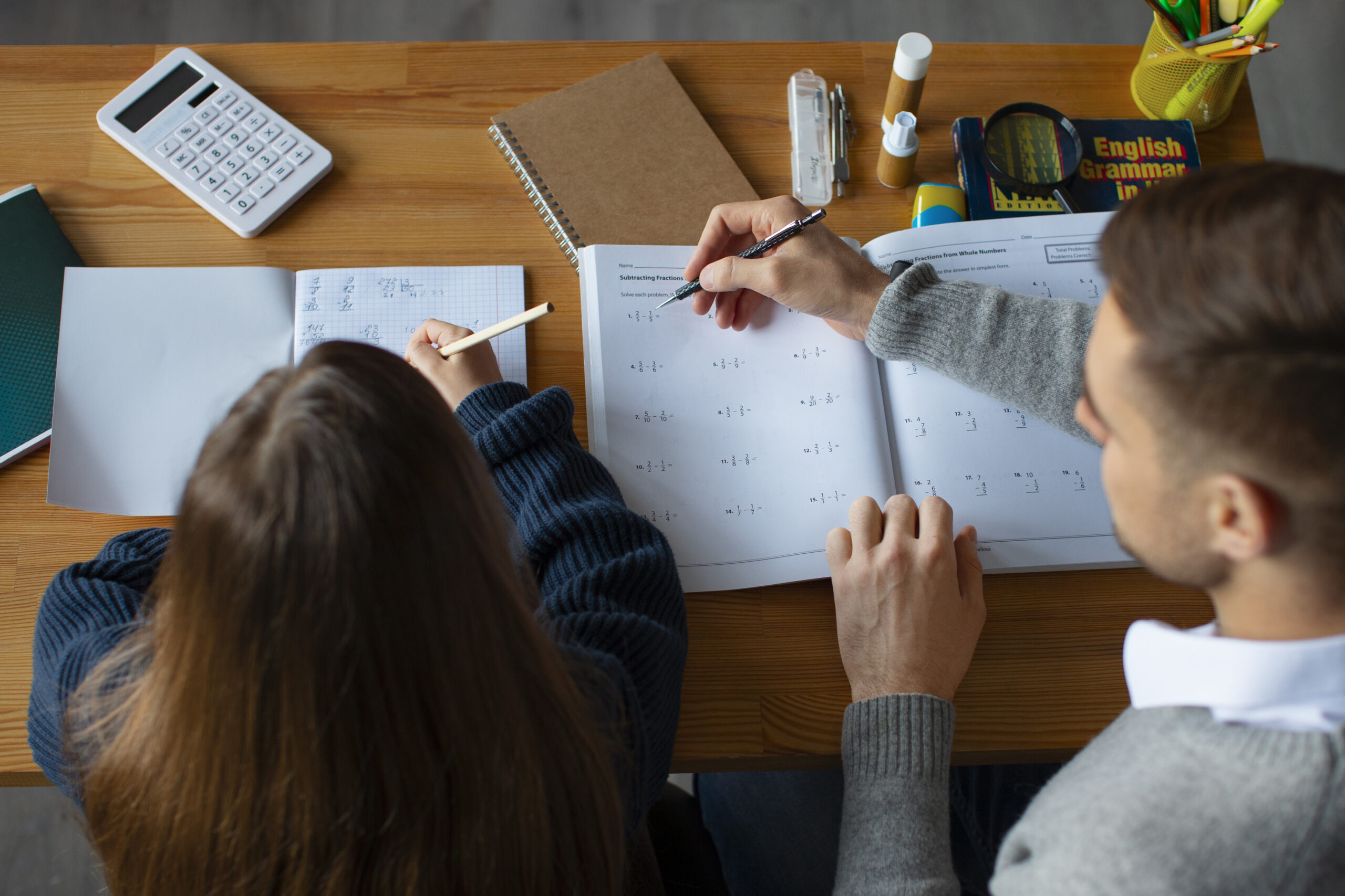 Diagnoza dysleksji i dyskalkulii. Dziewczynka odrabia lekcje z pomocą rodzica