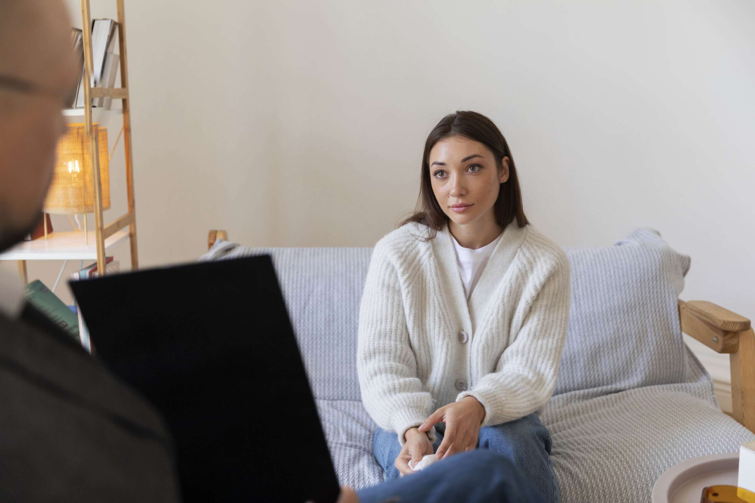 Kobieta w białym swetrze podczas sesji terapeutycznej.