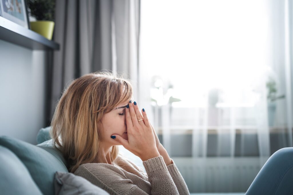 sad woman sitting on sofa at home thinking about utc scaled