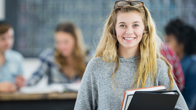 Uśmiechnięta kobieta w szarym swetrze