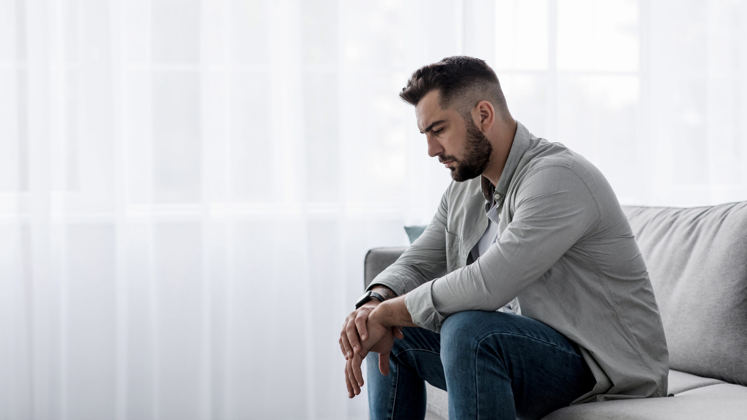 Nieszczęśliwy mężczyzna siedzący w samotności w pokoju.