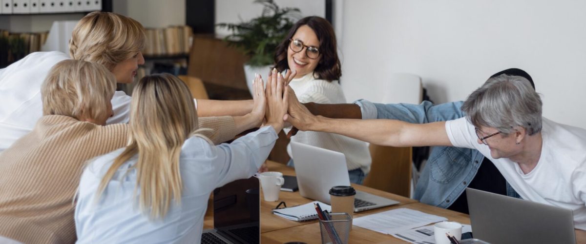 Radośni pracownicy firmy przybijający sobie piątki